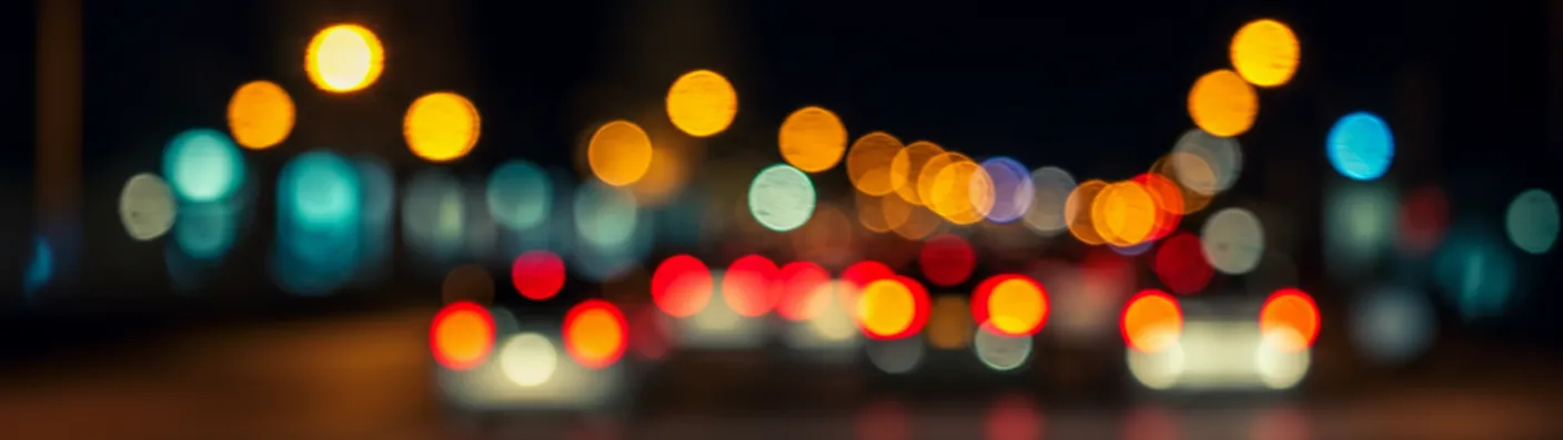 Blurred traffic lights and cars at night, illustrating everyday coverage questions