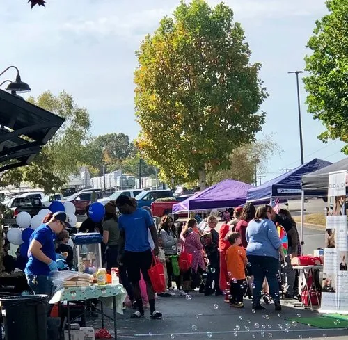 Neighbors gathering under tents at the Fall Safety Festival