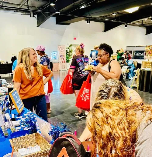 A busy community gathering brings neighbors together around The Goines Agency table.